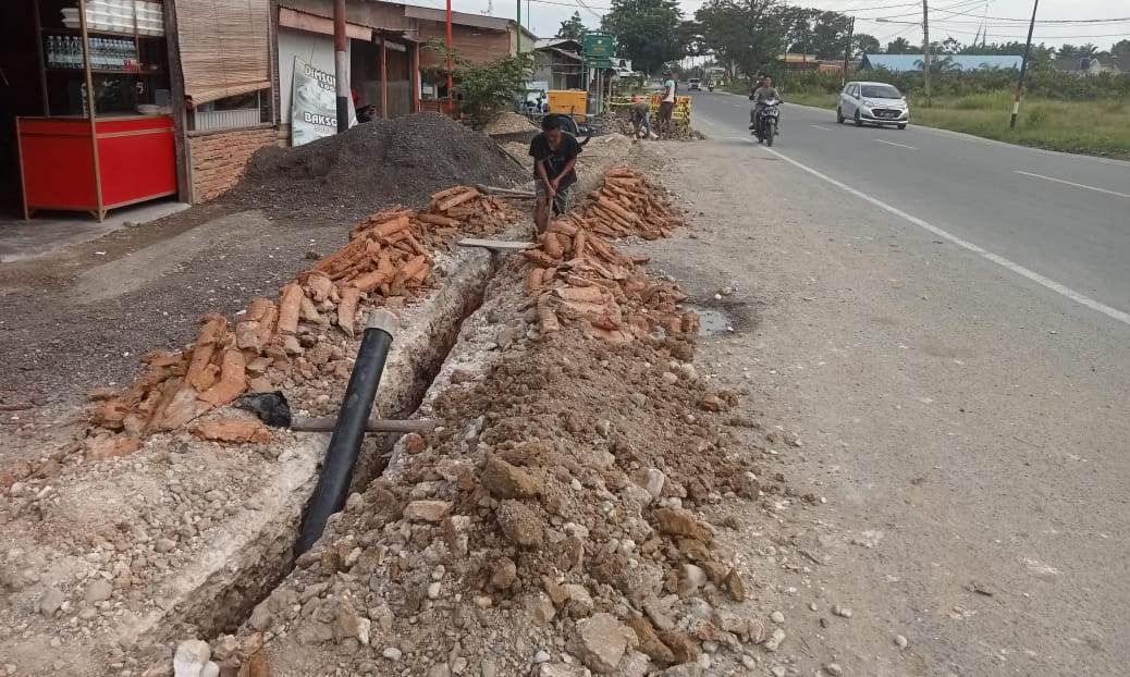 Pekerjaan penanaman pipa di Jalan lintas Medan-Banda, Gampong Sungai Lueng, Kecamatan Langsa Timur